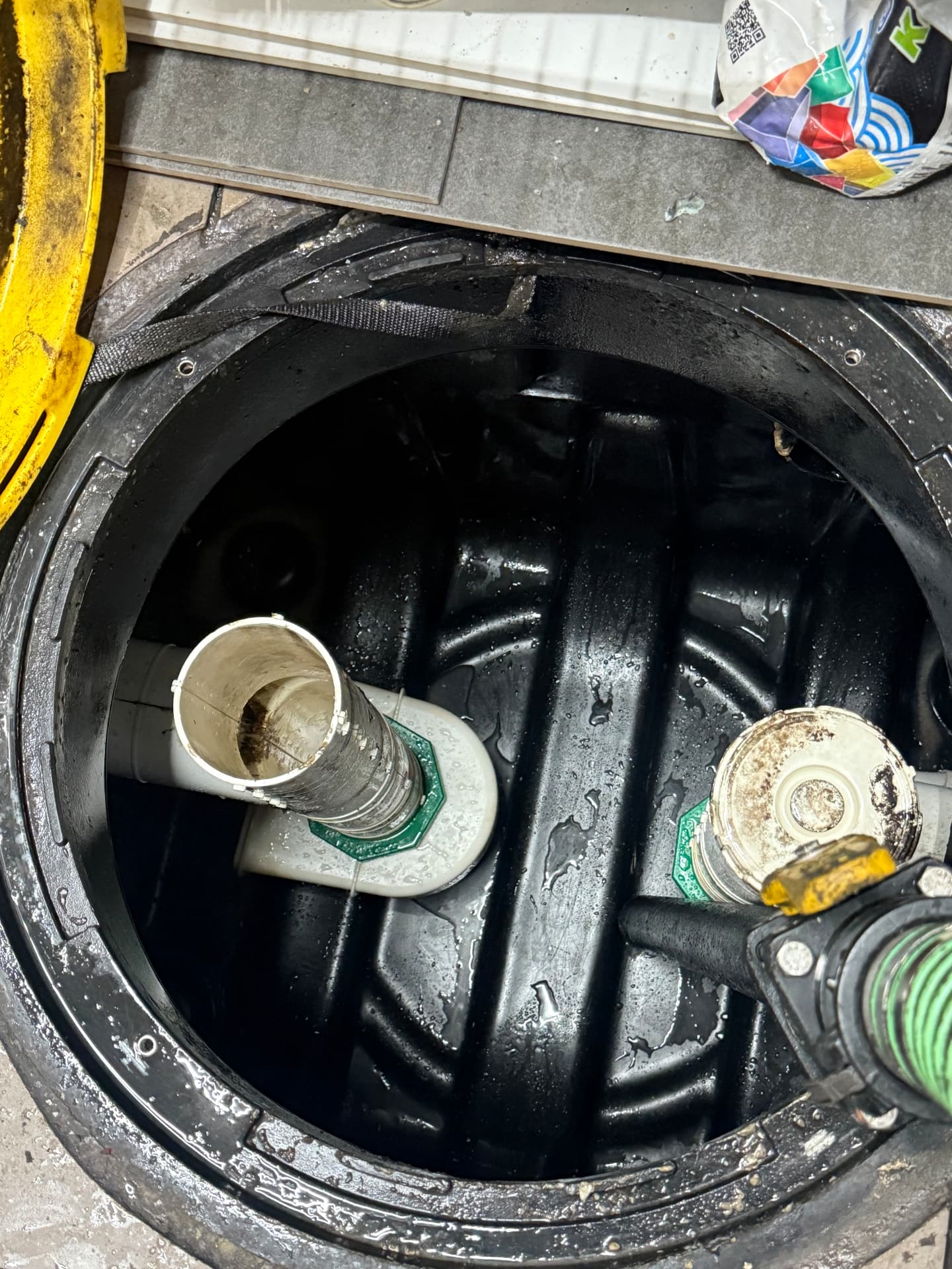 Clean grease interceptor interior with inlet and outlet tees visible after pumping