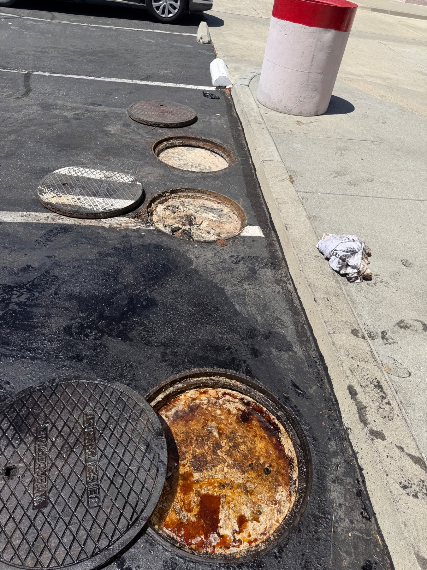Large outdoor grease interceptor with open manholes ready for pumping in Norco, California