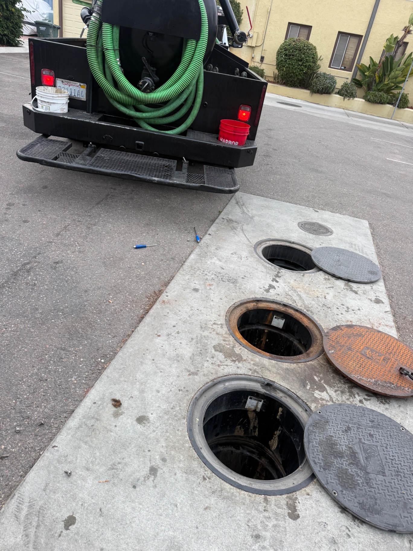 Large outdoor grease interceptor with open manholes ready for pumping in Menifee, California