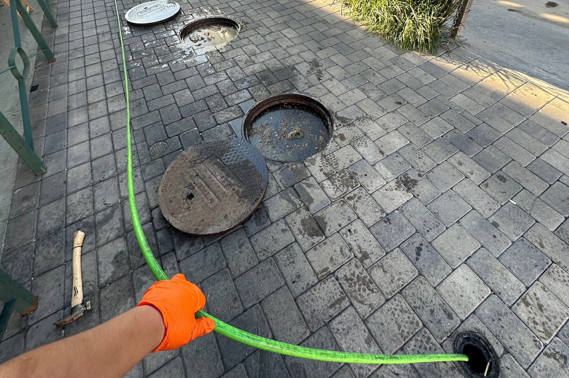 Multiple in-ground grease interceptor lids opened on a restaurant walkway