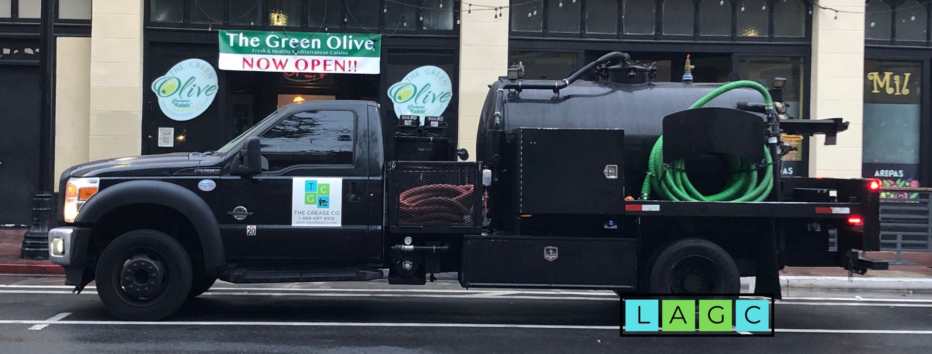 The Grease Company vacuum truck parked outside a restaurant for grease service